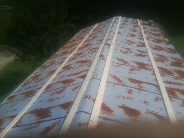 Rusted metal roof panels with new wood purlins before replacement — Storm Damage Roof Repair in Alverton by Roofing Brothers